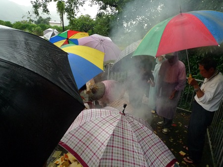 冒著颱風雨，關山社區居民祭拜後在公廨小廣場焚燒金紙。﹙攝影曾麗雲﹚P1110926