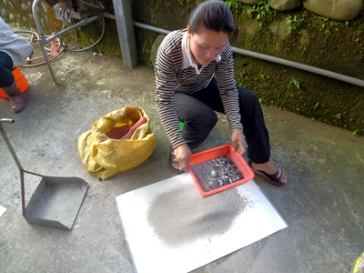從菲律賓遠嫁過來的羅貝娜，�將火灰過篩。﹙攝影蘇美玉﹚P1030661-1